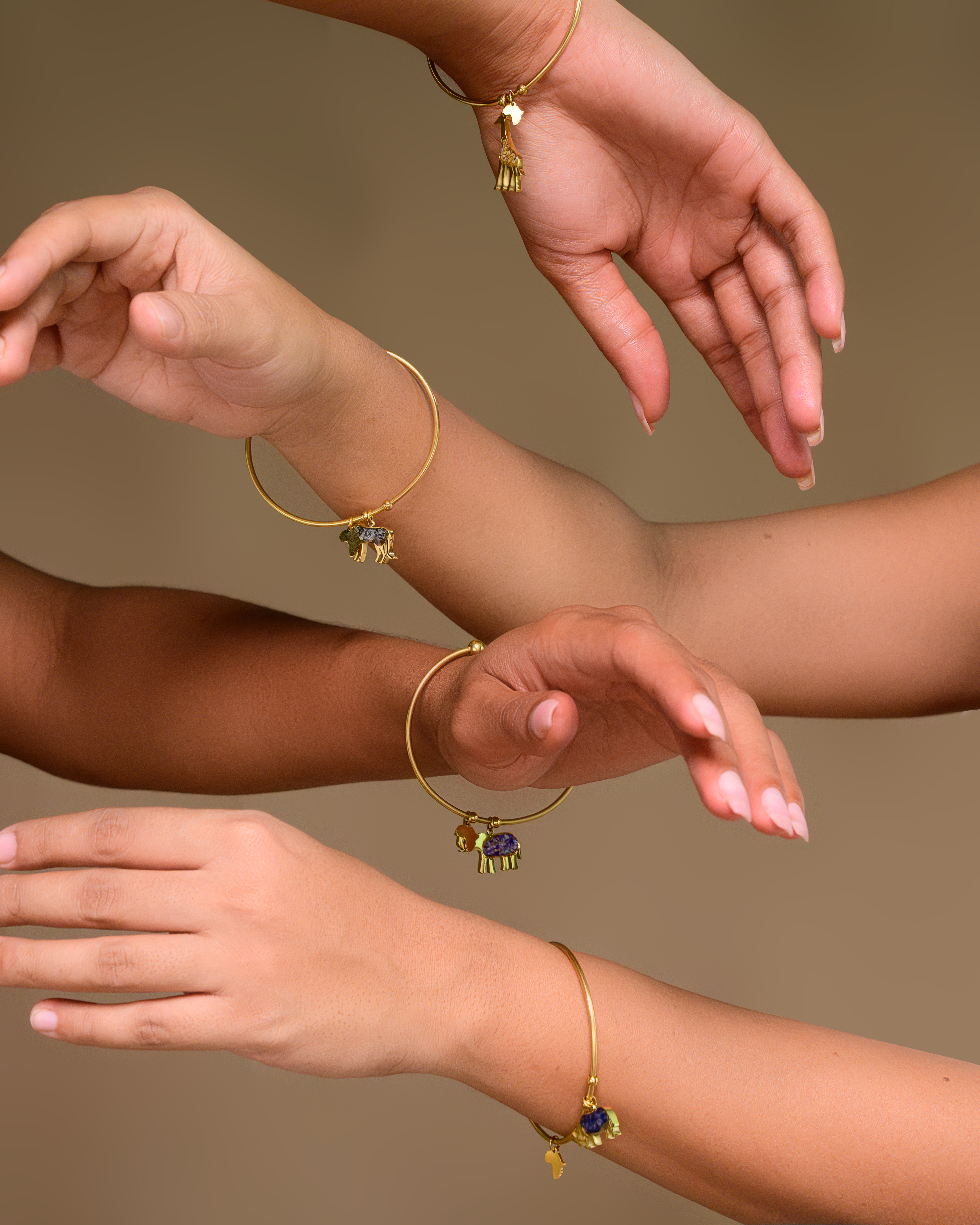 Gold charm bangles on models' arms